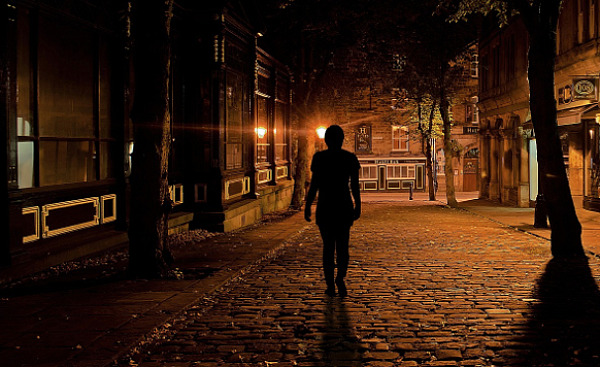 pessoa andando sozinha por uma rua escura