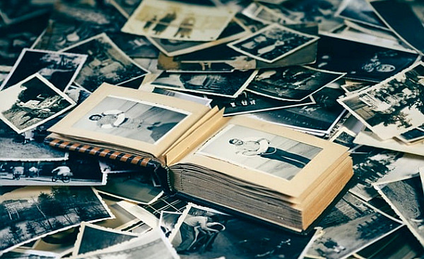 joukko vanhoja valokuvia ja vanhoja valokuvia sisältävä kirja