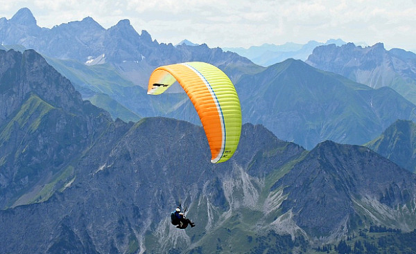 paraglider in de lucht nabij een bergachtig gebied