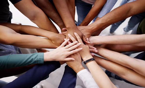 a circle of hands all piled up on top of each other in the center