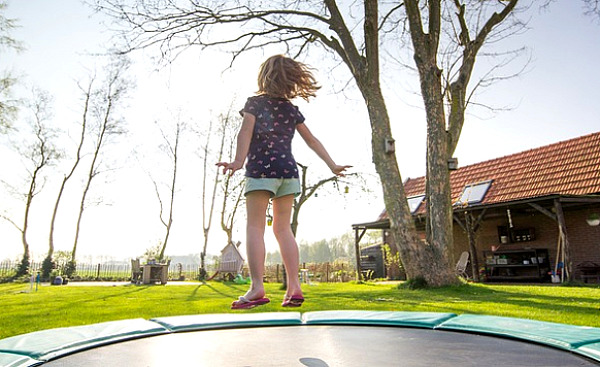 gadis muda melompat di atas trampolin