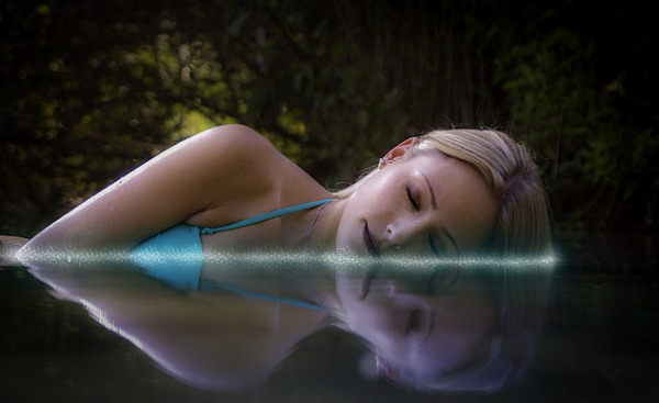 महिला लेटी हुई पानी में सो रही है