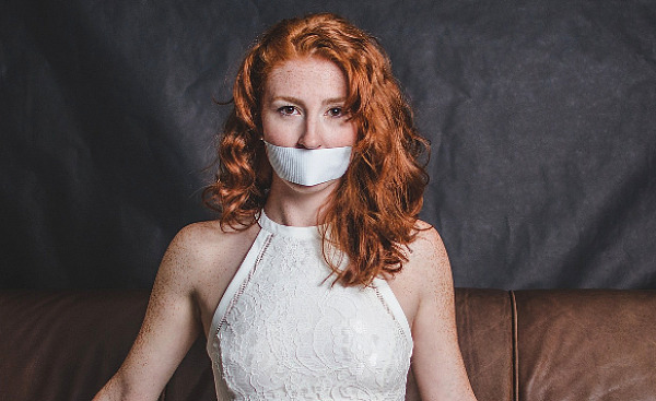 woman in evening gown silenced with tape on her mouth