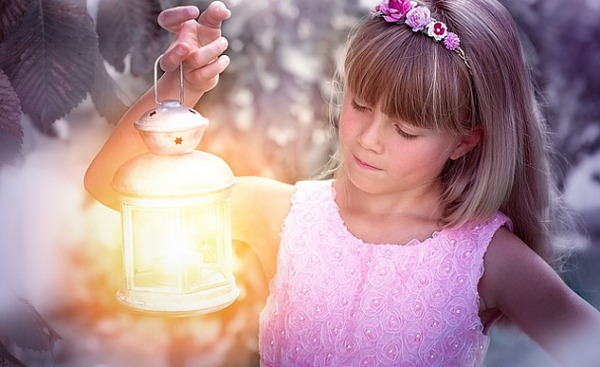 uma garota segurando uma lanterna brilhante