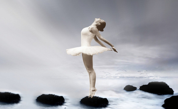 Ballerina steht auf Felsen im Wasser