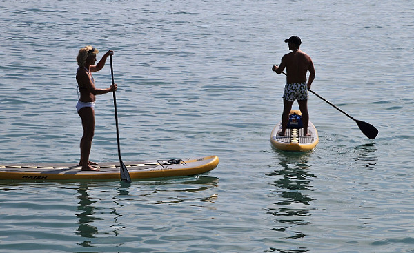 dalawang tao, isang lalaki at isang babae, sa mga paddle board