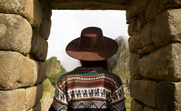 Mulher indiana sob um arco de pedra em Machu Picchu