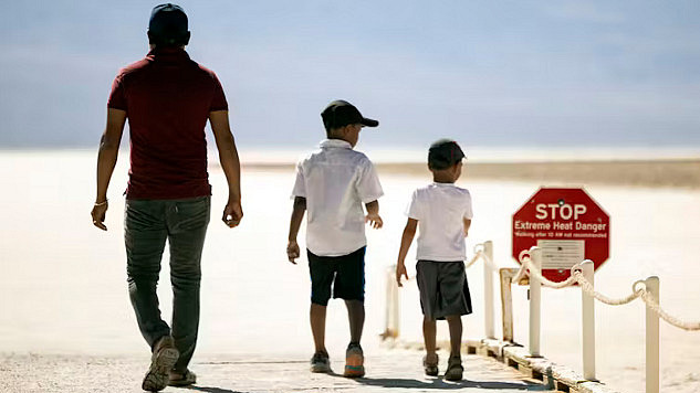 Sign warning of extreme heat danger in Death Valley during record-breaking heat waves in July 2024, highlighting climate change’s growing impact on global temperatures.