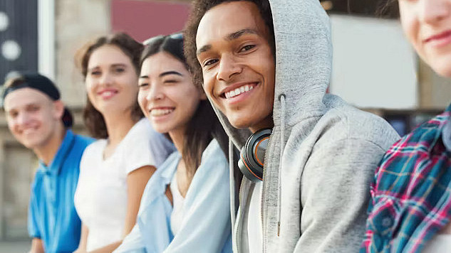 Teenager smiling while eating a healthy meal, illustrating the benefits of lifestyle changes on mental health.