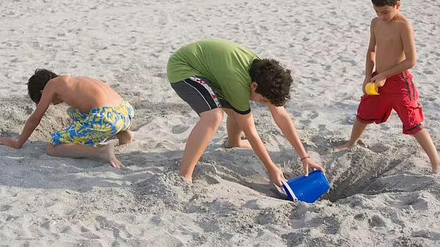 Children building sandcastles and tunnels this summer