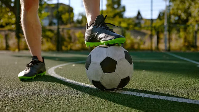 someone's foot on top of a soccer ball