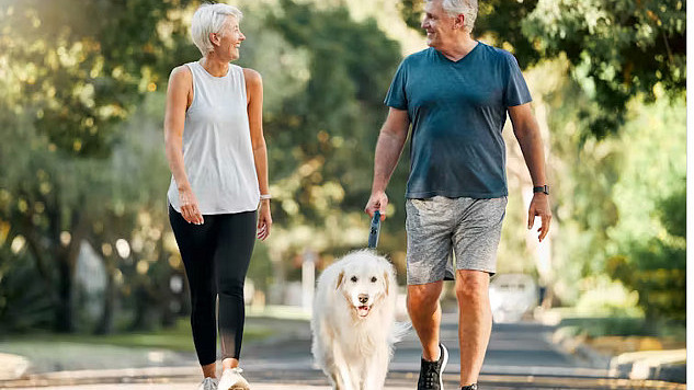 Person walking with an upright posture in a park, showing improved spinal health.