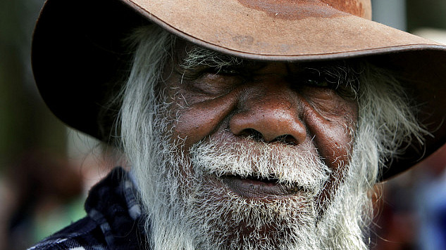 Indigenous elder teaching about traditional ecological knowledge with a backdrop of nature and climate-related imagery.