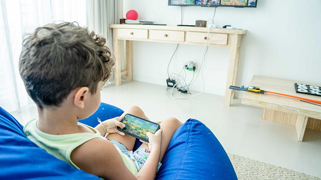 young boy playing a game on a smart phone