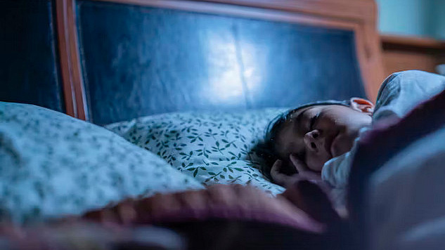 Child sleeping in bed with a soft toy, representing the importance of sleep for brain development and emotional health in children.