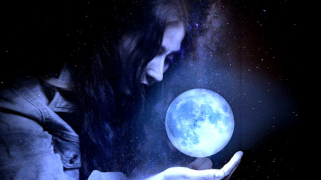 a woman holding the shining glove of Earth in her palm