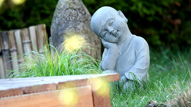 a small statue in a zen garden