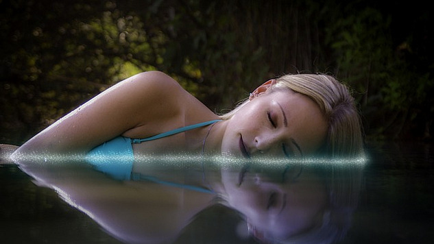 kvinne som legger seg ned og sover i vannet