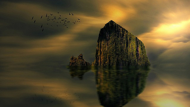 a big rock or boulder jutting out of the water and being reflected in the calm usrface of the lake