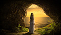 donna in piedi in una caverna buia che guarda verso il cielo luminoso