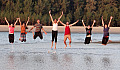 Eine Gruppe junger Erwachsener springt mitten in einem Fluss vor Freude