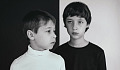 兩個小男孩，一個穿著白色，另一個穿著黑色，站在承包背景前