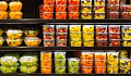 Sortiment av skuren frukt i plastbehållare på display till försäljning i snabbköpet