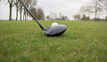 Крупный план клюшки для гольфа, расположенной прямо перед мячом для гольфа