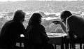tre persone sedute a un tavolo in una conversazione profonda
