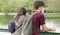 หนุ่มสาวคู่หนึ่งสวมหน้ากากอนามัยยืนบนสะพาน