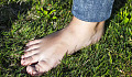picture of a person's bare foot standing on the grass