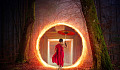 ung buddhistmunk, som bærer en paraply og går inn i en portal inn i en trestamme