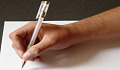 มือของบุคคลถือปากกาและการเขียน