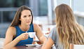 hai người phụ nữ đối mặt nhau uống cà phê
