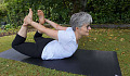 een oudere vrouw die buiten yoga doet