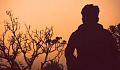 mężczyzna stojący samotnie na zewnątrz o zachodzie słońca