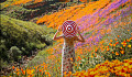 A woman in floral dress standing on the field of orange flowers. Image by Angelica Reyn.