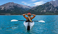 坐在湖中央皮划艇上放松的女人