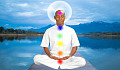 un uomo seduto in meditazione con i chakra illuminati