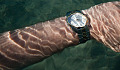 un braț care poartă un ceas de mână sub apă