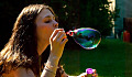 young woman blowing a soap bubble
