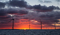 De zon komt op achter een offshore windmolenpark. Afbeelding: Aaron via Flickr