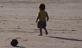 uma criança muito pequena sozinha na praia