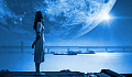 en kvinne som står med en enorm måne i bakgrunnen