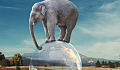 Elefant balanciert auf dem Globus des Planeten Erde