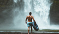 man getting ready to jump into a waterfall pool