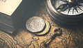 عکس یک کلید ، یک قطب نما ، سکه هایی که روی نقشه قدیمی قرار گرفته اند