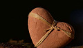 một trái tim làm bằng đá với một dải ruy băng xung quanh nó
