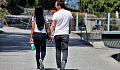sepasang suami isteri berjalan berpegangan tangan