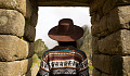 Machu Picchu'da taş bir kemerin altında duran Hintli kadın